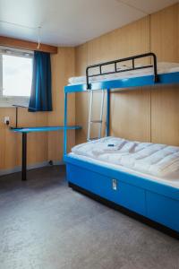 Pokój z 2 łóżkami piętrowymi i biurkiem w obiekcie ARCONA - Übernachten auf dem Wasser - direkt am Bontekai w mieście Wilhelmshaven