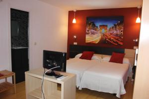 Una habitación de hotel con dos camas y un televisor. en Hostal Falfes, en Madrid
