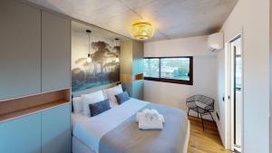 um quarto com uma grande cama branca e uma cadeira em Villa Ananda - Gâia - Harmonie avec vue mer et étangs em Carnon-Plage