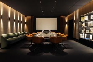 a conference room with a table and chairs and a screen at Hôtel Dame des Arts in Paris