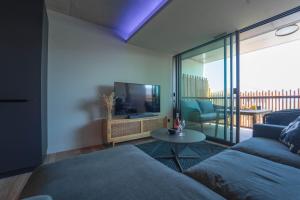 Uma televisão e/ou sistema de entretenimento em Villa Ananda - Gâia - Harmonie avec vue mer et étangs