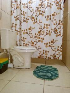 uma casa de banho com um WC e uma cortina de chuveiro em Villa Ágape - Chapada dos Veadeiros em Alto Paraíso de Goiás