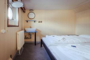 um quarto com 2 camas, um lavatório e um espelho em ARCONA - Übernachten auf dem Wasser - direkt am Bontekai em Wilhelmshaven