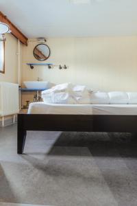 1 dormitorio con 1 cama grande con almohadas blancas en ARCONA - Übernachten auf dem Wasser - direkt am Bontekai en Wilhelmshaven