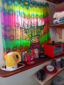 a rainbow curtain on a shelf in a kitchen at Villa Ágape - Chapada dos Veadeiros in Alto Paraíso de Goiás