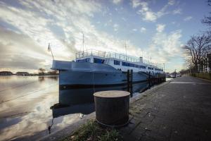 un barco azul y blanco sentado en el agua en ARCONA - Übernachten auf dem Wasser - direkt am Bontekai, en Wilhelmshaven