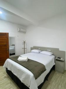 a bedroom with a large white bed with two pillows at Villa Brilho do Sol in Jericoacoara