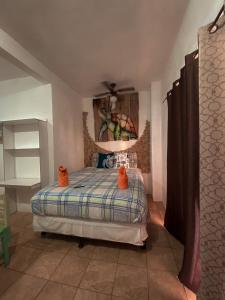 a bedroom with a bed with orange shoes on it at Hotel Maya Jade in Monterrico