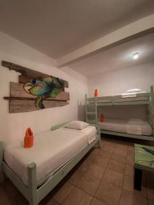 a bedroom with two bunk beds and a table at Hotel Maya Jade in Monterrico