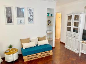 a living room with a blue bench and a tv at Hermoso Depto en el corazón de Nueva Cordoba in Córdoba
