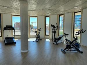 een fitnessruimte met diverse hometrainers in een kamer met ramen bij Casa Paraiso in Cartagena