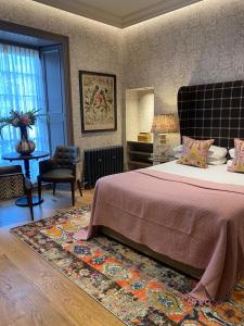 a bedroom with a bed and a chair and a rug at The Raeburn in Edinburgh