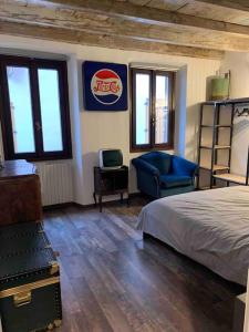 una camera con letto, sedia e finestre di NEON apartment a Cantù