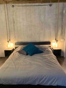 una camera da letto con un letto con cuscini blu e due luci di NEON apartment a Cantù