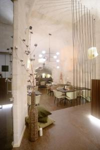 a room with tables and chairs and a vase with flowers in it at Le Malve Cave Retreat in Matera +42 photos