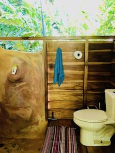 a bathroom with a toilet and a wooden wall at Casonita in Manzanillo