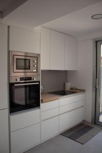 a kitchen with white cabinets and a microwave at Apartamento Catòlics 25 in Pollença