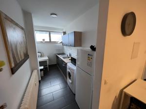 eine kleine Küche mit einem Kühlschrank, einer Waschmaschine und einem Trockner in der Unterkunft Wohnung in Troisdorf T02 in Troisdorf