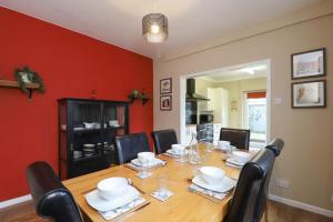 a dining room with a wooden table and black chairs at Kenmare Cottage in Shanklin