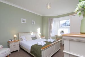 ein Schlafzimmer mit einem Bett mit Handtüchern darauf in der Unterkunft Kenmare Cottage in Shanklin