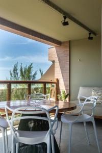 comedor con mesa y sillas en el balcón en Apartamento Lindo e Completo - Wai Wai Cumbuco, en Cumbuco