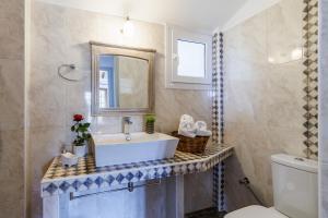 a bathroom with a sink and a mirror and a toilet at Irida House in Stafylos +39 photos