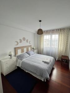 1 dormitorio con 1 cama grande con alfombra azul en Rapadouro, en Cangas de Morrazo