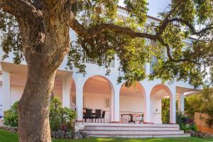 アラウリン・デ・ラ・トレにあるLovely Home Las Mañanas - Piscina, barbacoa y vistas Ideal Familiasのアーチと木のある白い大きな建物