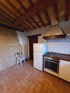 Il comprend une cuisine équipée d'une cuisinière et d'un réfrigérateur blanc. dans l'établissement Country House Marche Nascoste, à San Girolamo di Sopra 4 autres photos