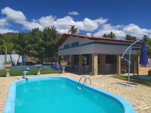a swimming pool in front of a house at Hospedagens Icapui Mare Blu in Icapuí