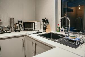 uma cozinha com um lavatório e um micro-ondas em Chatsworth St by Prestige Properties SA em Barrow in Furness