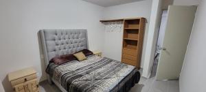 a small bedroom with a bed and a closet at Departamento Aeropuerto Puebla in Huejotzingo