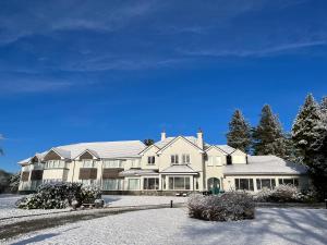a large white house with a roof at Loch Lein Country House in Killarney