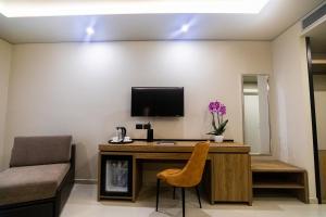 a room with a desk with a television and a chair at Kraal Hotel Vlore in Vlorë