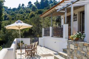 a patio with a table and an umbrella at Irida House in Stafylos