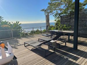 a deck with a ping pong table and an umbrella at Maison De Plage in Umdloti