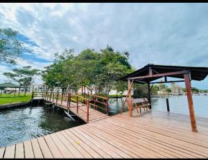 a wooden dock with a bench on the water at Apartamento nos Lencois Confort in Barreirinhas