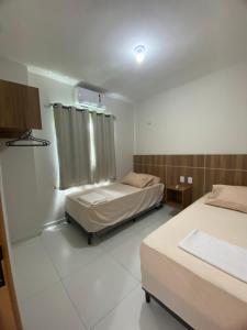 a hospital room with two beds and a window at Apartamento nos Lencois Confort in Barreirinhas