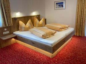two beds in a bedroom with a red carpet at Ferienhaus Ferwall in Sankt Anton am Arlberg