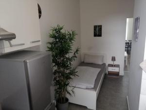 a room with a bed and two plants in it at Wohnung in Köln 1B in Cologne