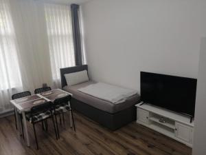 ein kleines Zimmer mit einem Bett und einem Flachbildfernseher in der Unterkunft Wohnung in Köln 1B in Köln