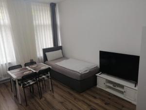 a small room with a bed and a flat screen tv at Wohnung in Köln 1B in Cologne