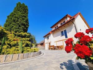 ein Haus mit roten Blumen im Innenhof in der Unterkunft Ranczo Popowice in Pątnów