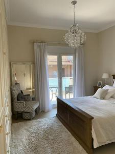 um quarto com uma cama grande e um lustre em Villa Oleander Agios Nikolaos Loutra Edipsou em Loutra Edipsou