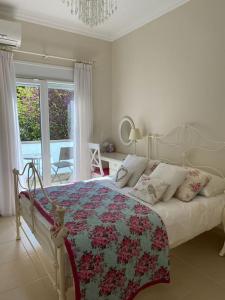 ルトラ・エディプソスにあるVilla Oleander Agios Nikolaos Loutra Edipsouの白いベッドルーム(カラフルな毛布付きのベッド付)