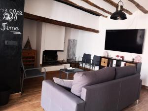 a living room with a couch and a flat screen tv at Casa Rural El Llano Quintanilla in Yecla