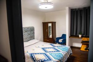 a bedroom with a bed with a blue and white quilt at Departamento Glorieta La Normal in Guadalajara