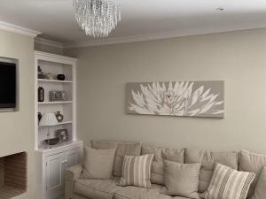 uma sala de estar com um sofá e um lustre em Villa Oleander Agios Nikolaos Loutra Edipsou em Loutra Edipsou