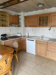a kitchen with wooden cabinets and a sink and a table at MaRe FeWo in Hettingen