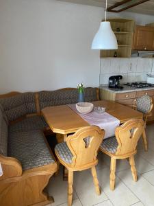 a kitchen with a wooden table with two chairs and a table and a table at MaRe FeWo in Hettingen